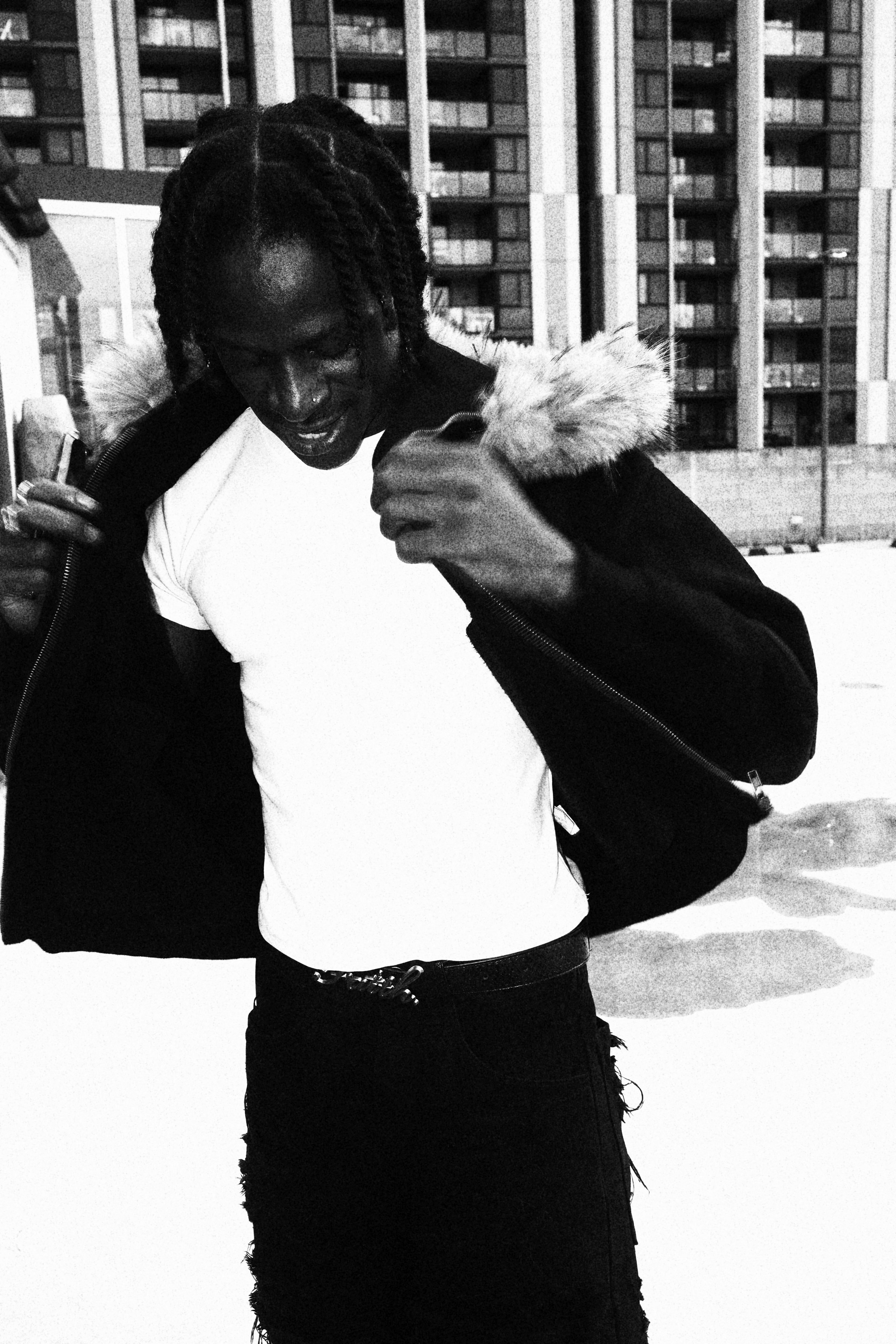 Black and white photo of a person holding a flower in an urban setting
